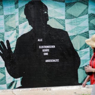 Μια γυναίκα κοιτάζει το έργο του Στέφαν Ρολόφ «Πέρα από το τείχος» στο West Side Gallery στο Βερολίνο