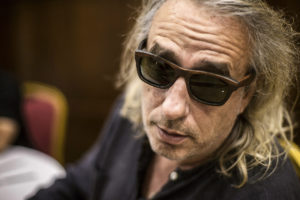 Μία μέρα, εντελώς ξαφνικά, επισκέφτηκαν τον Γιάννη Αγγελάκα δύο γοητευτικοί υπονομευτές κάθε ανθρώπινης βεβαιότητας με όρεξη για κουβέντα